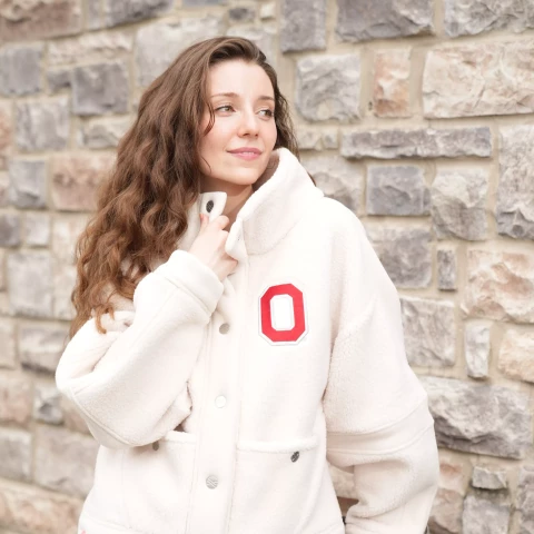 one model wears a cream fleece with a block o on the chest 