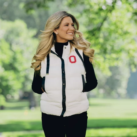 one model wears a cream colored ohio state vest on a green background