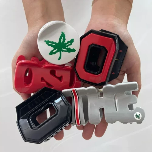 5 various design claw clips being held in 2 hands from a birds eye view 