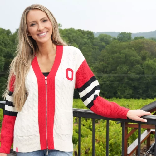 one model stands against a green background with an ohio state sweater on 