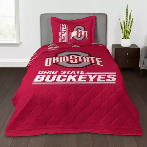 A red quilted Ohio State Buckeyes throw blanket and matching sham displayed on a bed in a bedroom.