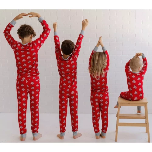 4 children stand side by side facing a way from the camera in an O-H-I-O pose. they are all wearing matching ohio state two-piece pajamas 