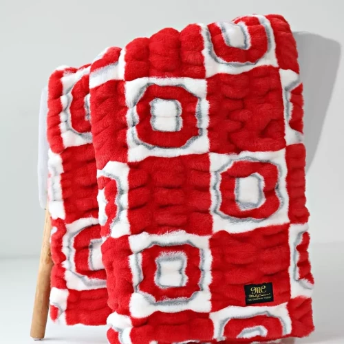 Red and white checkered Minky Couture blanket featuring a textured pattern with white and red Ohio State logos in the squares, with a small brand tag in the corner.