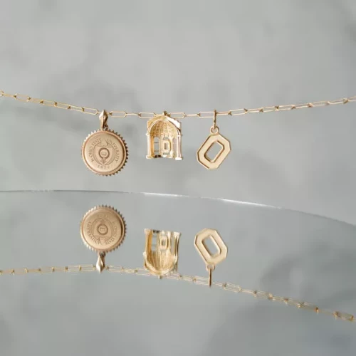 three ohio state themed pendants on a gold chain 