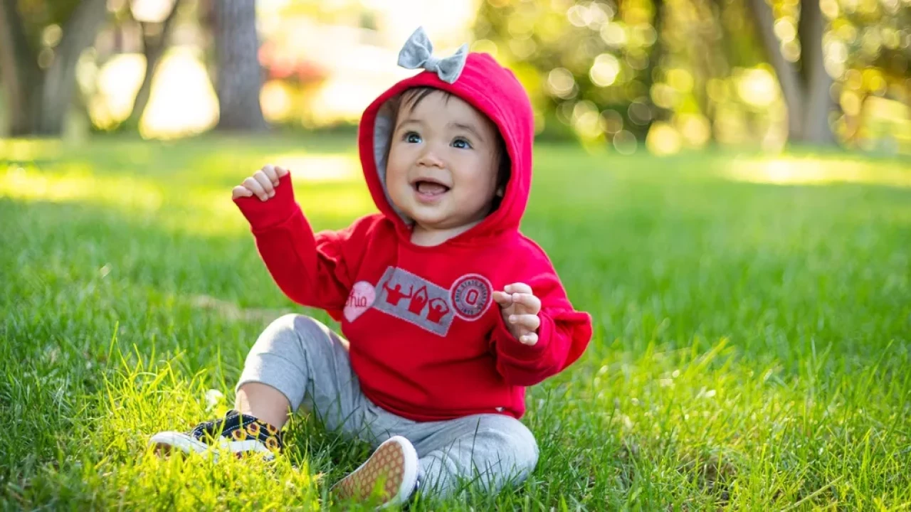 Red infant hoodie gray O-H-I-O silhouette with script ohio heart decal, and university seal decal with a gray soft fabric bow on hood. 