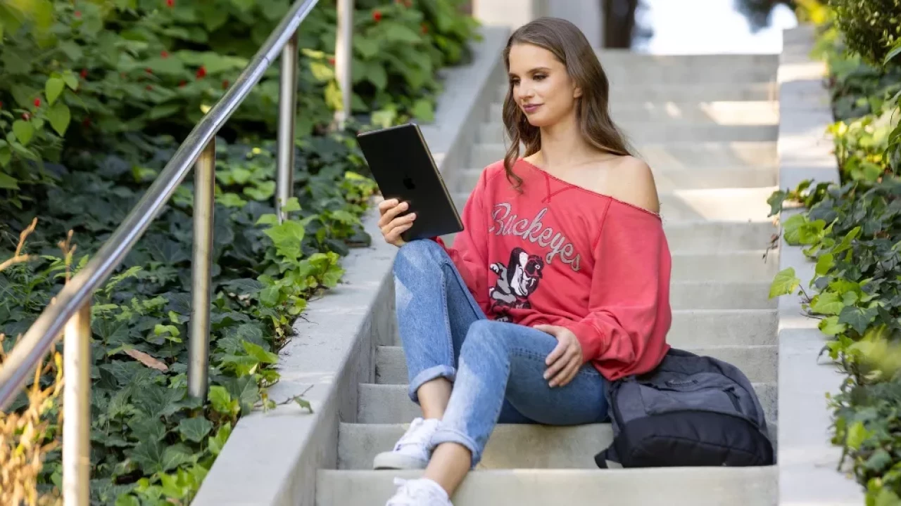 Model wearing Red off the shoulder long-sleeve tee-shirt. Printed script 