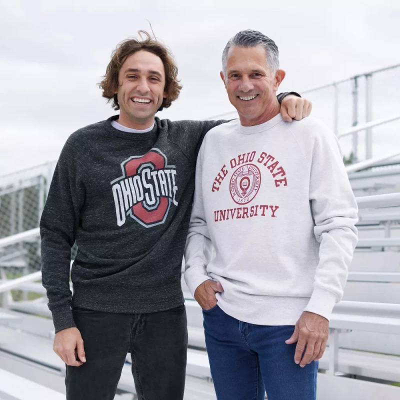 2 male models stand side by side in ohio state crewneck sweaters on a set of bleachers 